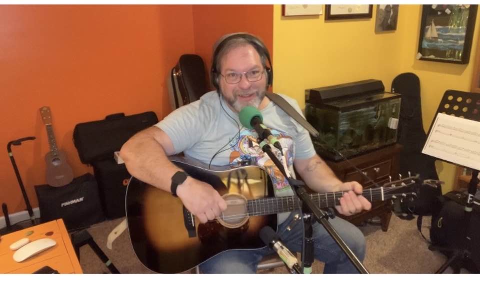 Michael playing acoustic guitar in his studio